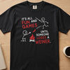 Black t-shirt with "It's all fun and games until someone loses a weiner" text and stick figures.
